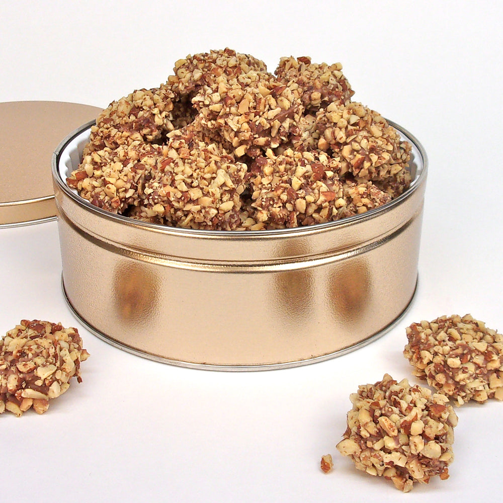 Gold tin filled with nut covered English Toffee pieces on a white background.