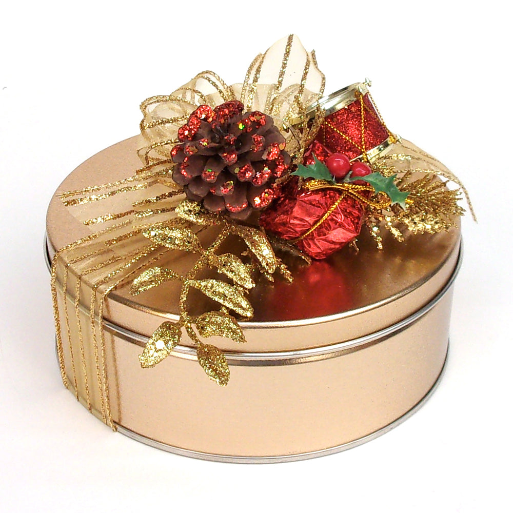 Decorative round gold tin with red and gold ornaments on a white background